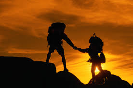 Blog Two Hikers Holding Hands at Sunset